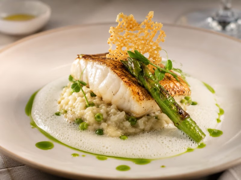 Wolffish with buttermilk-sambai jus, asparagus, smoked potato and vadouvan crisp